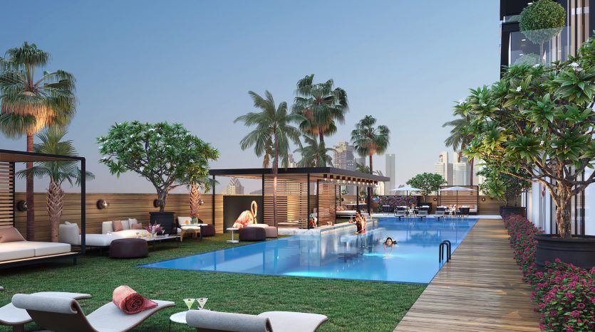 Piscine luxueuse sur le toit avec chaises longues, cabanes et verdure luxuriante, sur fond de gratte-ciel au crépuscule à Dubaï. Les gens se détendent et nagent dans un cadre animé et serein.
