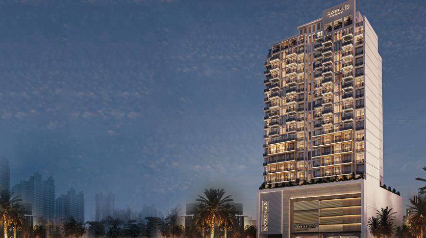 Illustration d'un hôtel moderne de grande hauteur au crépuscule à Dubaï, avec des fenêtres éclairées et un logo au sommet. Bordée de palmiers, la rue en face présente des feux tricolores flous.