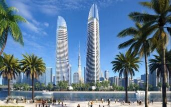 Un paysage urbain animé avec deux grands gratte-ciel en verre par une journée ensoleillée, avec des palmiers au premier plan et des gens profitant d'activités au bord d'une promenade au bord de l'eau à Dubaï.
