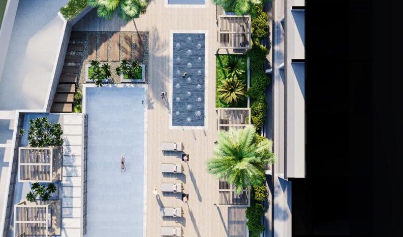 Vue aérienne d'un bâtiment moderne doté d'équipements sur le toit, notamment d'une piscine, de coins salons et de jardins paysagers entourés de structures architecturales à Dubaï.
