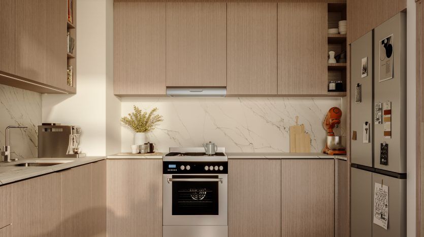 Une cuisine moderne dans un appartement de Dubaï avec des armoires en bois, des comptoirs en marbre et des appareils électroménagers en acier inoxydable, dont un four encastré. La pièce est chaleureusement éclairée par un tapis décoratif et de petites plantes, rehaussant l'ambiance.