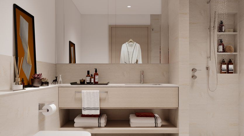 Une salle de bains moderne dans un appartement « Palace Residences North Emaar » à Dubaï, avec des tons beiges, une vasque flottante avec un grand miroir, un espace douche éclairé et des accents décoratifs.