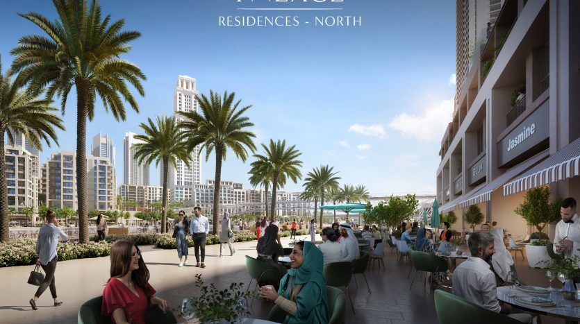 Une salle à manger extérieure animée dans des résidences de palais au nord d'Emaar, où les gens prennent leurs repas sous les palmiers, au milieu de bâtiments modernes et d'un ciel bleu clair à Dubaï.
