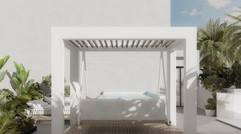 Un coin salon extérieur minimaliste d'une villa à Dubaï, comprenant un auvent carré blanc avec une balançoire suspendue, du parquet et une piscine en arrière-plan, sur un ciel dégagé.