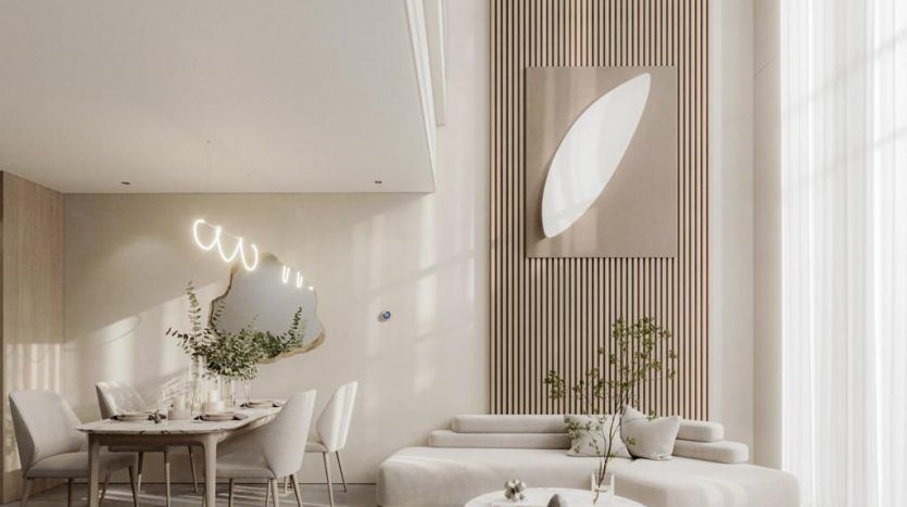 Un salon et une salle à manger modernes et minimalistes aux tons neutres. Il dispose d'un mobilier élégant, de murs en panneaux de bois et d'un éclairage contemporain. Une table à manger pour quatre et un coin salon confortable dans une villa