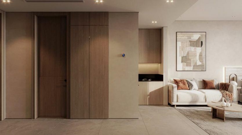 Une villa moderne à Dubaï aux tons neutres comprenant un canapé avec des coussins, une œuvre d'art murale et des portes coulissantes discrètes qui se fondent dans les panneaux muraux en bois.