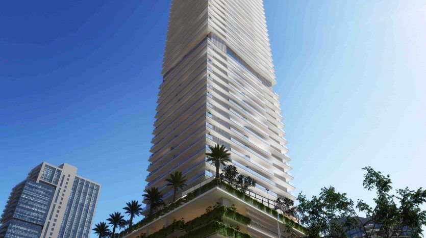 Un grand gratte-ciel moderne portant le logo St. Regis, présentant une verdure luxuriante sur les balcons inférieurs sous un ciel bleu clair à Dubaï.