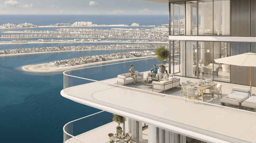 Zwei Personen entspannen sich auf dem luxuriösen Balkon eines Apartments in Dubai mit Blick auf eine urbane Küstenlandschaft mit hellblauem Wasser darunter, ausgestattet mit modernen Outdoor-Möbeln und einem Essbereich.