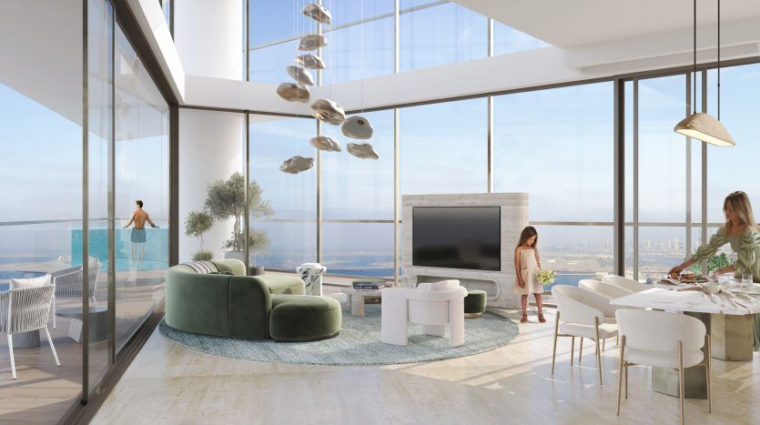 Intérieur d'un appartement luxueux de grande hauteur à Dubaï doté de fenêtres panoramiques avec vue sur l'océan. Deux femmes conversent dans un salon moderne à la décoration stylée, tandis qu'un homme profite du balcon extérieur.