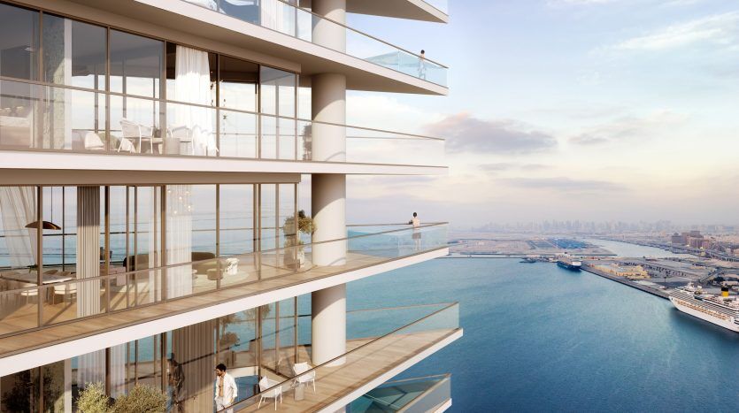 Immeuble d'appartements moderne de grande hauteur à Dubaï avec de grands balcons donnant sur un port animé avec des navires. La façade du bâtiment présente de grandes surfaces vitrées et un design contemporain, ce qui en fait une opportunité d'investissement de premier ordre à Dubaï.