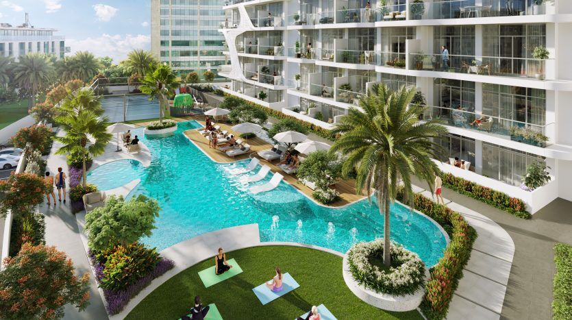 Une piscine luxueuse de style complexe avec des gens qui se détendent, des palmiers, des jardins luxuriants et des immeubles modernes de grande hauteur à Dubaï entourent la piscine serpentine.
