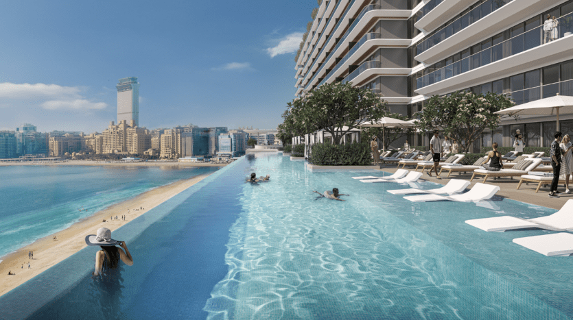 Luxuriöser Infinity-Pool an einem sonnigen Tag mit Blick auf einen Strand und die Stadtlandschaft von Dubai, mit faulenzenden und schwimmenden Menschen.