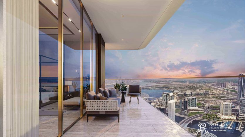 Luxueux balcon d'appartement de grande hauteur à Dubaï surplombant un paysage urbain au coucher du soleil avec des sièges moelleux et des balustrades en verre, offrant une vue panoramique sur l'horizon urbain et la rivière.