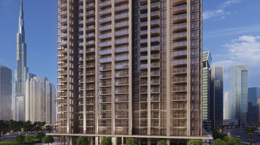 Un immeuble résidentiel moderne de grande hauteur dans une ville animée aux façades de verre, situé à proximité d'une rue avec des voitures et de la verdure, avec des gratte-ciel, dont une très haute tour, en arrière-plan