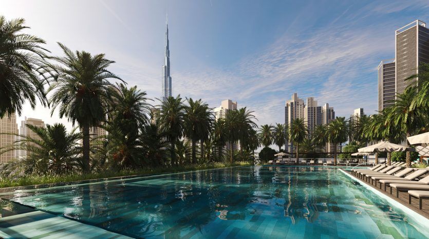 Une luxueuse piscine extérieure entourée de palmiers, avec des chaises longues sur le côté, surplombant les toits de la ville moderne avec de grands gratte-ciel sous un ciel bleu clair à Dubaï.