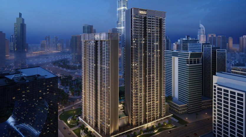 Vue aérienne d'une ville moderne au crépuscule avec des gratte-ciel illuminés, de larges rues et une architecture urbaine dense, parfaite pour investir à Dubaï.