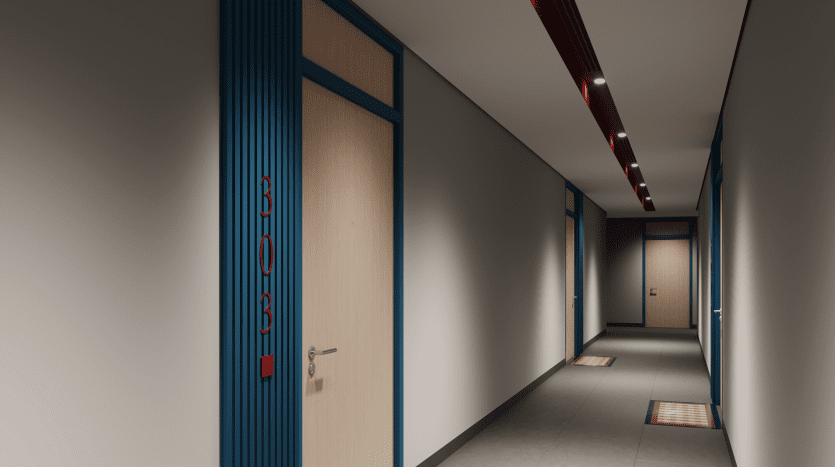 Un couloir moderne, conçu par The Edge Select Group, présente un sol gris lisse et des plafonniers rouges. Des portes en bois aux cadres bleus bordent les murs, avec le numéro 808 visible sur l'une d'elles. Des tapis à carreaux colorés à l'extérieur de chaque porte ajoutent une touche de chaleur.