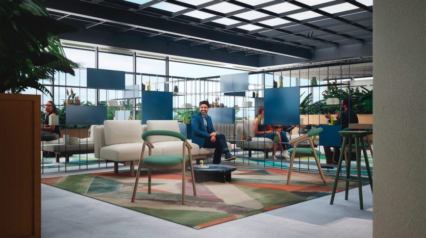 Un salon de bureau moderne dans une agence immobilière de Dubaï avec un homme en costume bleu assis sur un canapé blanc, entouré de meubles élégants, de plantes et de collègues engagés dans des discussions.