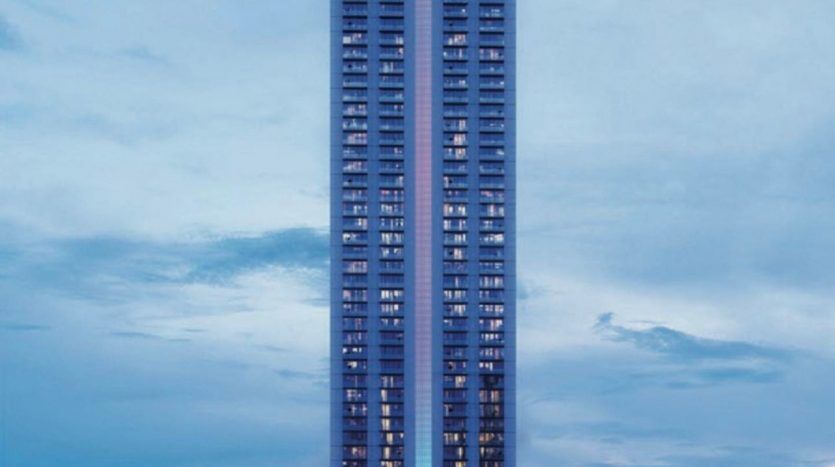 Un grand gratte-ciel moderne se dresse sur un ciel crépusculaire, avec des lumières allumées à certaines fenêtres. Le bâtiment présente une conception segmentée unique avec de grands balcons et une verdure luxuriante à différents niveaux, ce qui en fait