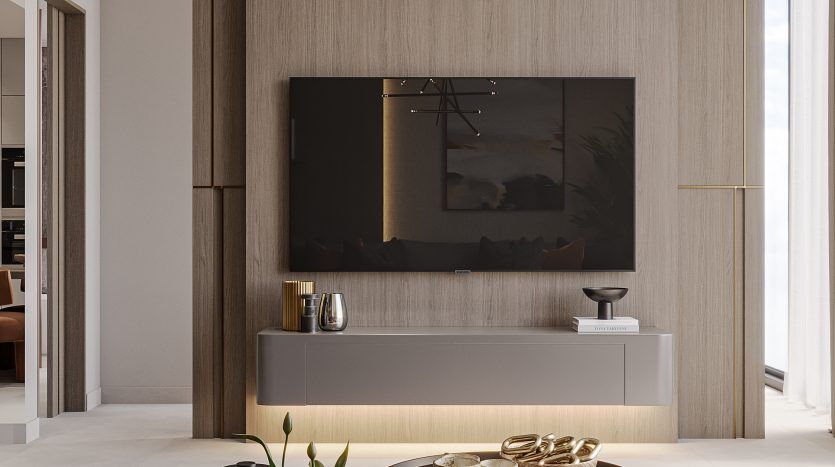 Un salon moderne dans une villa de Dubaï comprenant un élégant meuble multimédia en bois avec une télévision grand écran, deux tables basses rondes sombres et un tapis texturé dans des tons terre. Un luminaire angulaire en or ajoute