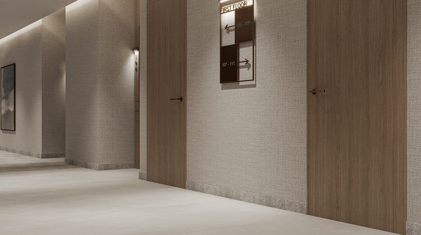 Une villa moderne à Dubaï avec des panneaux de bois allongés sur les murs et les portes, avec un éclairage encastré au plafond. Un écran numérique affichant des publicités est fixé au mur.