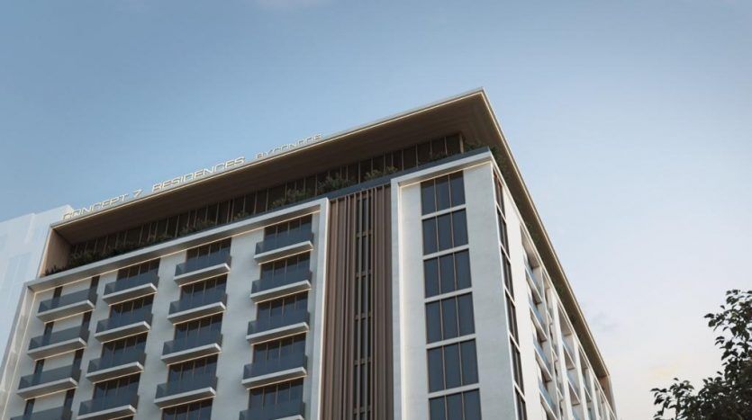 Vue en contre-plongée d'un immeuble moderne de grande hauteur nommé "Résidences Avancez" sous un ciel bleu clair au coucher du soleil, commercialisé par une agence immobilière de Dubaï.