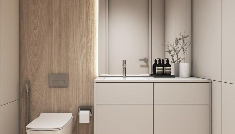 Une salle de bains moderne dans une villa de Dubaï comprenant des toilettes élégantes à côté d'un mur lambrissé, un meuble lavabo blanc intégré et un miroir à l'esthétique minimaliste.