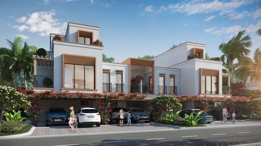 Immeubles résidentiels modernes de deux étages avec balcons ornés de fleurs, sous un ciel bleu clair. Les gens marchent et les voitures sont garées devant ces appartements recherchés à Dubaï.