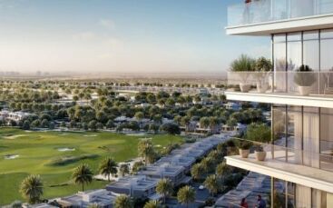 Blick von einem hoch gelegenen Balkon auf einen weitläufigen, üppigen Golfplatz, der von modernen, niedrigen Wohngebäuden umgeben ist, unter einem klaren Himmel in Dubai.
