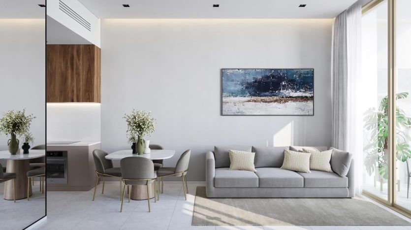 Un salon moderne et élégant avec un canapé gris, un coin repas et de grandes fenêtres menant à un balcon dans un luxueux appartement de Dubaï. La chambre présente une décoration minimaliste avec une grande peinture abstraite au