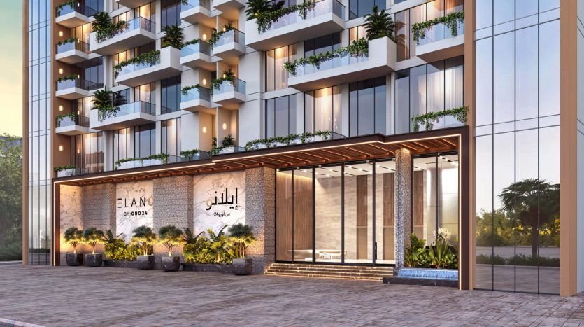 Entrée d'un immeuble résidentiel moderne à Dubaï avec le nom « elano » au-dessus de la porte, avec des fenêtres en verre réfléchissantes, plusieurs balcons avec des plantes vertes et une zone d'entrée chaleureusement éclairée.