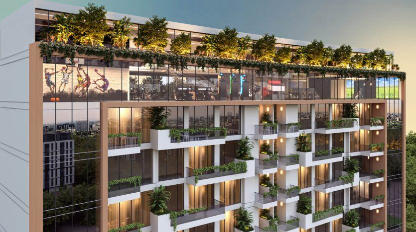 Un immeuble d'appartements moderne de plusieurs étages à Dubaï au crépuscule, doté de balcons spacieux avec des plantes vertes luxuriantes et d'un toit orné de verdure vibrante et de mobilier d'extérieur.