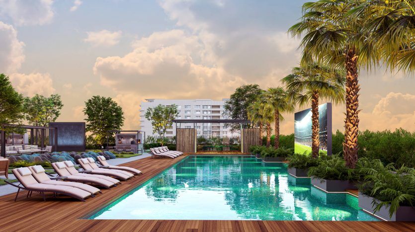 Cadre luxueux au bord de la piscine au coucher du soleil avec chaises longues, palmiers luxuriants et piscine tranquille, à côté de structures architecturales modernes à Dubaï.
