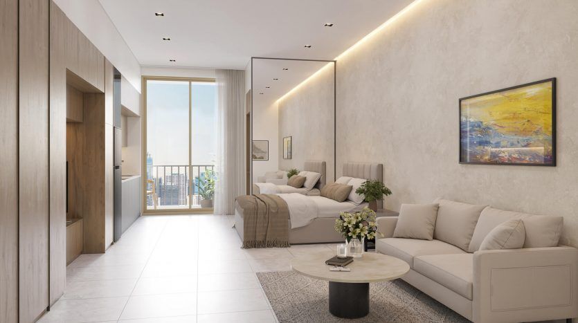 Un salon moderne et lumineux avec un canapé beige, une table en marbre et une composition florale. De grandes fenêtres offrent une vue sur la ville de Dubaï, un lit est visible dans la pièce adjacente et des œuvres d'art