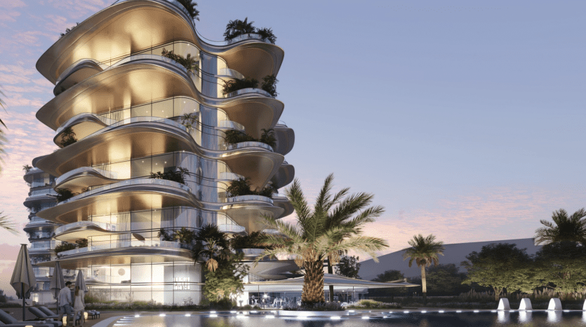 Bâtiment moderne de plusieurs étages avec des balcons incurvés éclairés par des lumières chaudes au crépuscule, entouré de palmiers et d'un plan d'eau réfléchissant au premier plan, une opportunité d'investissement idéale à Dubaï.