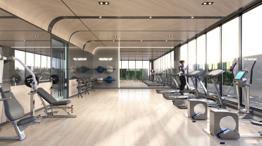Intérieur de salle de sport moderne comprenant des rangées de tapis roulants, d'appareils de musculation et de poids libres avec de grandes fenêtres et un design élégant et minimaliste situé dans une villa de premier ordre à Dubaï.