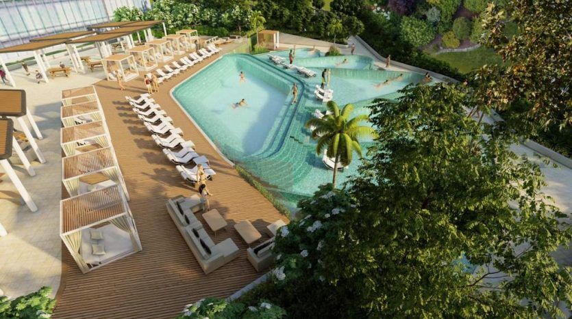 Aerial image of a luxurious outdoor pool in a Dubai villa surrounded by sun loungers and palm trees, with people swimming and relaxing in a serene landscaped setting.