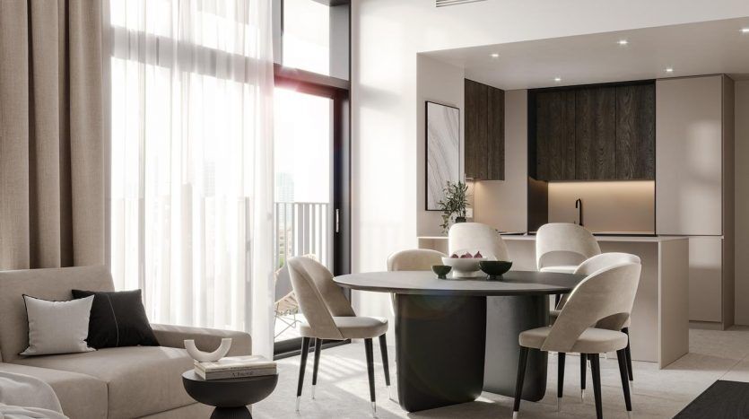 Modern living room in a Dubai apartment with a gray sofa, a round dining table with four chairs, parquet flooring and large windows with transparent curtains, creating a bright, airy space.