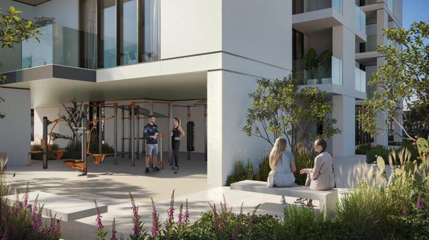 Courtyard of a modern apartment complex in Dubai with residents enjoying a variety of facilities: some working out in an open-air gym and others seated, engaging in conversation. Lush greenery and elegant architecture.