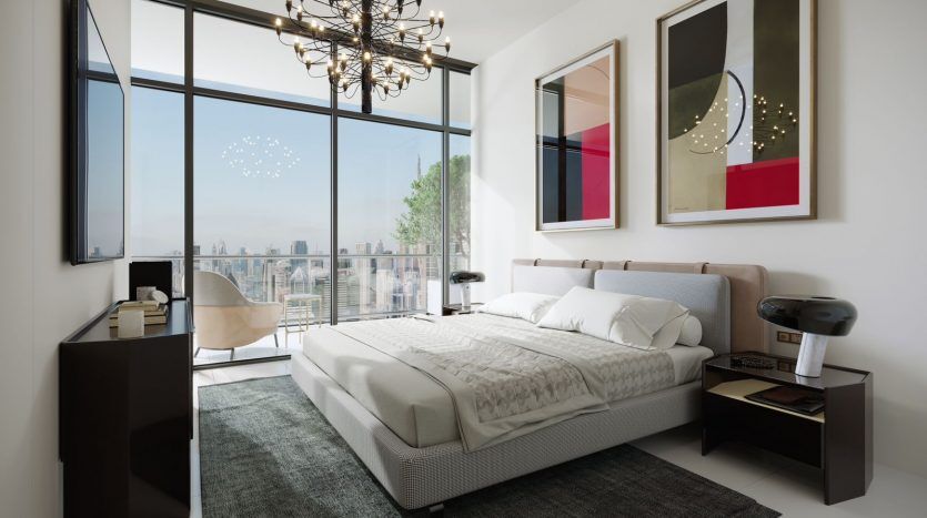 Chambre moderne dans un appartement de Dubaï comprenant un grand lit avec une couette blanche, des œuvres d'art abstraites sur les murs, un lustre saisissant et de grandes fenêtres offrant une vue sur le paysage urbain.