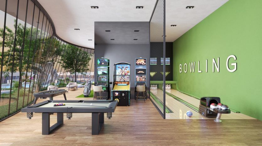 Intérieur d'une piste de bowling moderne avec une signalisation claire, comprenant une table de billard, des jeux d'arcade et des pistes de bowling. Des murs vert vif et un mobilier élégant et épuré créent un espace de loisirs accueillant, idéal pour investir à Dubaï.