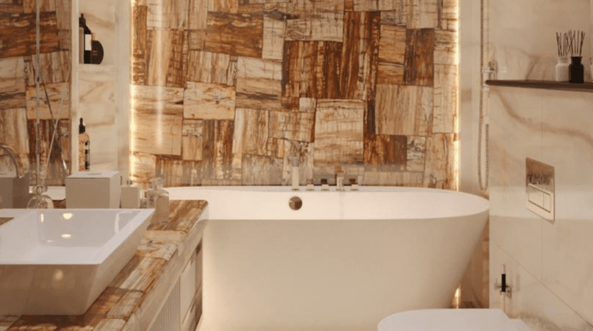 Une salle de bains moderne dans une luxueuse villa à Dubaï, dotée d'une grande baignoire autoportante, d'un lavabo rectangulaire et de murs aux motifs de marbre uniques aux teintes chaudes, éclairés par un éclairage tamisé.