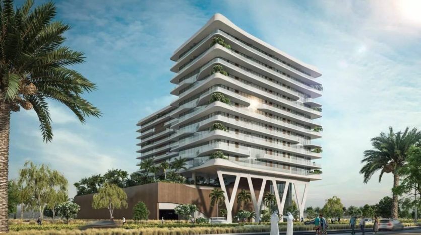 Bâtiment moderne à plusieurs étages avec des terrasses distinctes et superposées remplies de verdure. Il présente une conception architecturale blanche unique sous un ciel clair et constitue un excellent investissement à Dubaï, entouré d'un aménagement paysager luxuriant.