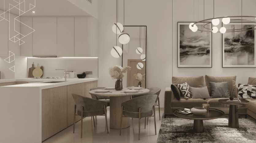 Salon moderne avec une cuisine élégante sur la gauche, dotée de comptoirs blancs et d'armoires en bois. Un coin salon confortable avec un canapé vert, des coussins décoratifs et une table basse ronde se trouve sous des suspensions élégantes