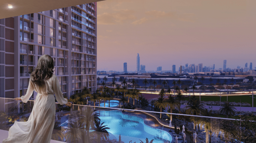 Une femme vêtue d'une robe longue se tient sur le balcon d'un appartement de Dubaï au crépuscule, surplombant un paysage urbain avec des gratte-ciel et une piscine éclairée en contrebas, reflétant le ciel rose du soir.