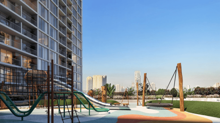 Une aire de jeux moderne avec des équipements colorés devant un immeuble résidentiel de grande hauteur, sous un ciel bleu clair, avec la villa Dubaï en arrière-plan.