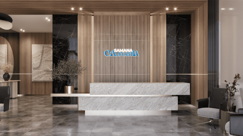Hall d'entrée d'un immeuble de bureaux moderne aux finitions élégantes en bois et en marbre, comprenant une grande réception, avec le logo « samaná dubai » sur un panneau en bois rétro-éclairé, flanqué de plantes
