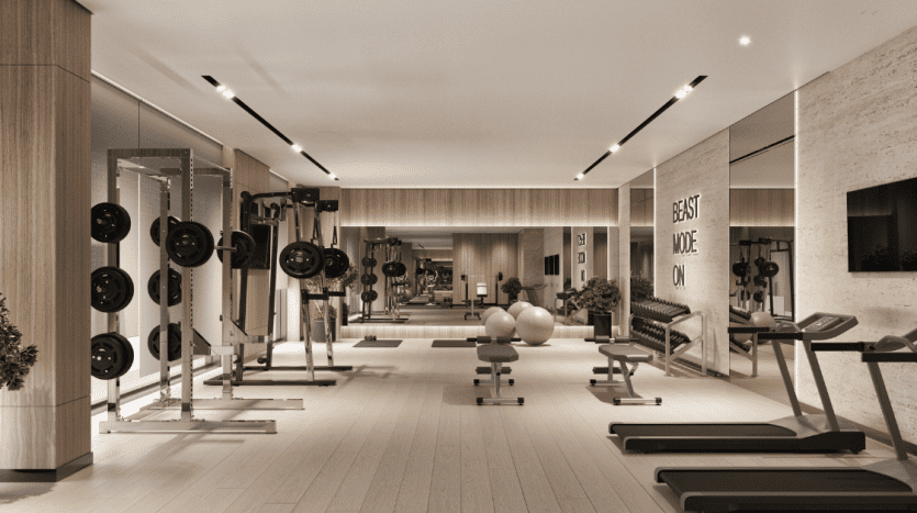 Un intérieur de salle de sport moderne dans un appartement haut de gamme à Dubaï, comprenant de nombreuses stations d'haltérophilie et tapis roulants, un design minimaliste avec des accents en bois, un éclairage lumineux et des panneaux de motivation comme « mode bête activé »