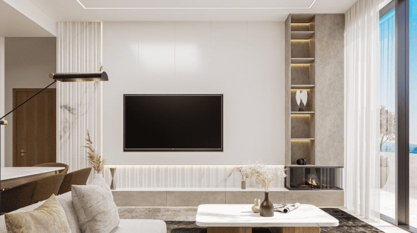 Un salon moderne dans un appartement de Dubaï avec une grande télévision sur un mur blanc, une cheminée, des étagères minimalistes au décor, un canapé et de grandes fenêtres offrant une vue sur la plage.