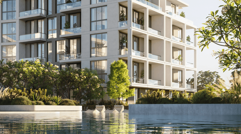 Immeuble d'appartements moderne à Dubaï avec de spacieux balcons sur une piscine réfléchissante, entouré d'une verdure luxuriante, représentant un environnement de vie urbain serein.